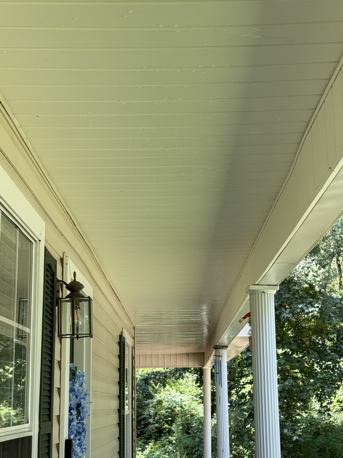 Freshly soft washed porch ceiling and siding on a Monroe home